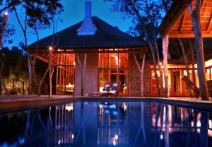 a house with a swimming pool in front of a house at Trogon House and Forest Spa in The Crags