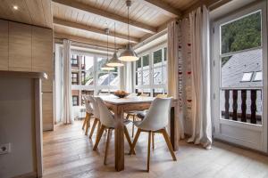 a dining room with a table and chairs and windows at FLOC DE NEU de Alma de Nieve in Baqueira-Beret