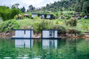 two tiny houses on the water in a lake at Hotel Pietrasanta in Guatapé