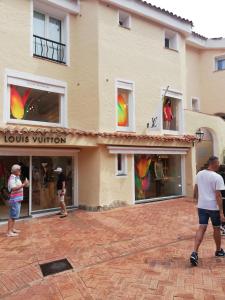 un grupo de personas de pie en frente de una tienda en Residenza Chrysalis Bay en Porto Cervo