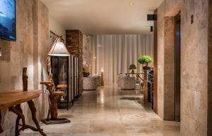 Tirat KarmelKedem Hotel - Adults Only的走廊上设有配有桌椅的大堂