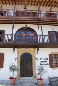 a building with a large door and a balcony at ATRATSA Mountain Suites in Kalopanayiotis