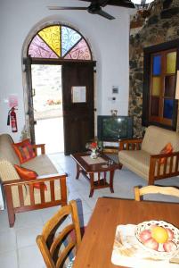 a living room with a table and chairs and a tv at ATRATSA Mountain Suites in Kalopanayiotis