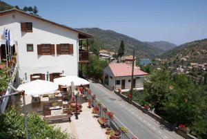a building with tables and umbrellas next to a road at ATRATSA Mountain Suites in Kalopanayiotis