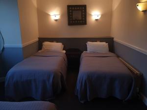 a hotel room with two beds and two lamps at The Olde Swan Hotel in Chertsey