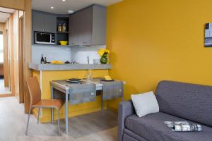 una pequeña cocina con mesa y sofá en una habitación en Aparthotel Adagio Paris XV, en París