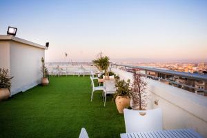 a balcony with tables and chairs on a roof at Satori Hotel in Haifa