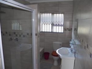 a bathroom with a shower and a sink and a toilet at 26 Pelser Plaat Meerensee in Richards Bay