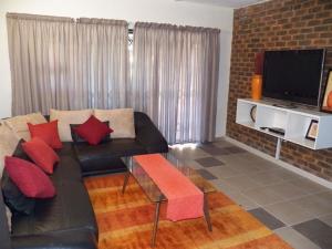 a living room with a couch and a tv at 26 Pelser Plaat Meerensee in Richards Bay