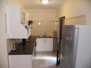 a kitchen with a white refrigerator and a sink at 26 Pelser Plaat Meerensee in Richards Bay