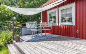a deck with two chairs and a table on a red house at Fårbo in Gissebo