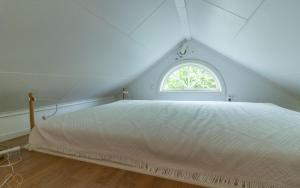 a bedroom with a white bed and a window at Fårbo in Gissebo