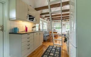 a kitchen with white cabinets and a dining room at Fårbo in Gissebo