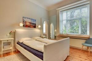 a bedroom with a large bed and a window at Grand Apartments - Monte Cassino Blanco in Sopot