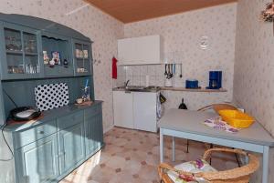 eine Küche mit blauen Schränken und einem Tisch in der Unterkunft Sehr günstiger Bungalow für 3 Personen auf Rügen in Sagard