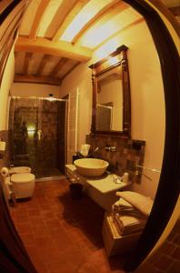 a bathroom with a sink and a toilet and a mirror at Albergo Ristorante Garibaldi in Cisterna dʼAsti