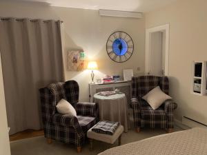 The Grapevine Studio في كامبريدج: غرفة نوم فيها كرسيين وطاولة وساعة