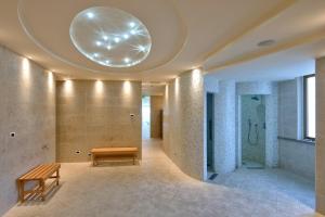 a lobby with a bench and a large orb on the ceiling at Hotel Terme Marine Leopoldo II TERME & SPA in Marina di Grosseto