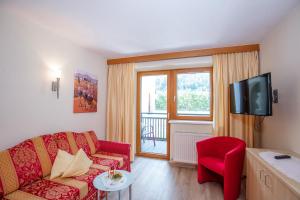 Trofana Appartements في سولدن: غرفة معيشة مع أريكة حمراء وتلفزيون