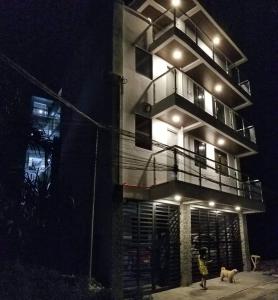 a person and a dog standing in front of a building at JSK Apartment in Bacoor