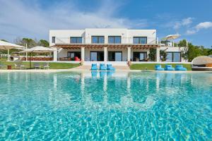 a villa with a swimming pool in front of a house at Fiframar in Sant Josep de Sa Talaia