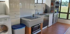 une cuisine avec un évier et une machine à laver dans l'établissement Lourenço House, à Póvoa de Varzim 24 autres photos
