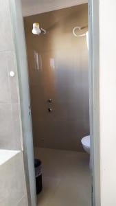 baño con aseo y puerta a la ducha en Departamento Piso 1 en Asunción