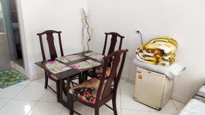 mesa, 2 sillas, mesa pequeña y nevera. en Departamento Piso 1, en Asunción
