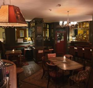 a restaurant with tables and chairs and a chandelier at The Olde Swan Hotel in Chertsey