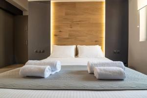 a bedroom with a large bed with two towels on it at MOS Luxury City Suites - The Loft in Chania Town