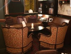 a living room with a couch and a candle on a table at The Olde Swan Hotel in Chertsey