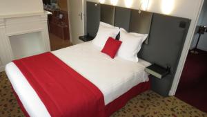 a bedroom with a large bed with red and white pillows at LOGIS - Belle Hôtel, Lille-Ouest in Bailleul