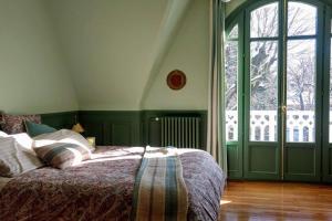 a bedroom with a bed and a large window at Villa de caractère 8 à 15p, 350 m2 - 15 mn Paris, 10 mn Versailles in La Celle-Saint-Cloud
