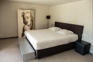 Un dormitorio con una cama con una foto de un hombre en Villa Farfalla, en Bredene