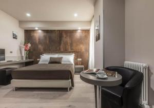 Un dormitorio con una cama, una mesa y una silla. en Astoria Deluxe rooms, en Bolonia