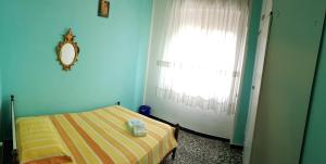 a blue room with a bed and a window at B&B In Centro in San Benedetto del Tronto