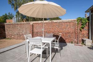a table and chairs with an umbrella on a patio at Le Temple, Studios & Appartement in Arras