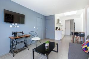 a living room with blue walls and a table and chairs at Le Temple, Studios & Appartement in Arras