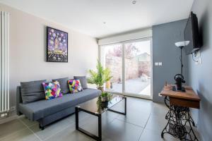 a living room with a couch and a large window at Le Temple, Studios & Appartement in Arras