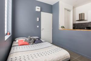 a bedroom with a bed with a blue wall at Le Temple, Studios & Appartement in Arras