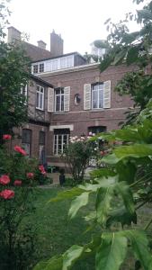 uma grande casa de tijolos com um quintal com flores em Jules Verne em Amiens
