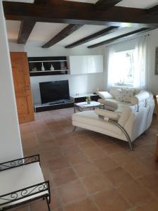 a living room with white furniture and a flat screen tv at Ferienhaus Gogelhopf in Unterschneidheim