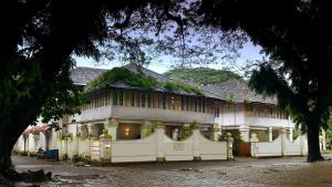 a large white house with a white fence at Neemrana's- Tower House in Cochin