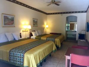 a hotel room with two beds with yellow and blue sheets at Texas Inn and Suites RGV in Edinburg