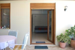 una puerta que conduce a un patio con mesa y sillas en Villa with a pool in Lefkogia en Lefkogeia