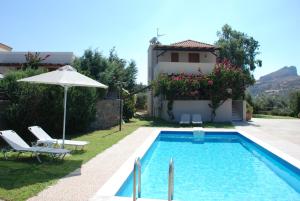 a villa with a swimming pool and a house at Villa with a pool in Lefkogia in Lefkogeia