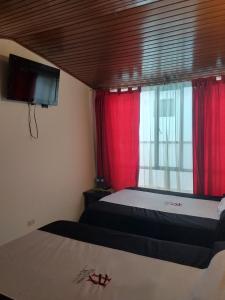 パイパにあるHotel Hortensia Realのベッドルーム1室(ベッド2台付)、赤いカーテン付きの窓が備わります。