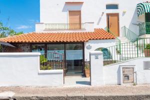 Casa blanca con puertas de cristal y balcón en Maison Twentyfive en Isquia