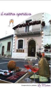 einen Tisch mit Speisen und Weingläsern vor einem Gebäude in der Unterkunft La Maison in Vallata