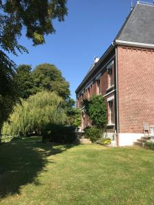 Mesnil-Martinsart的住宿－Bed & Breakfast au Château de Martinsart，前面有草坪的砖砌建筑